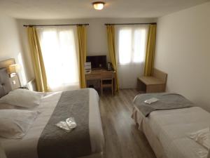 Ліжко або ліжка в номері Hôtel Les Comtes de Pardiac