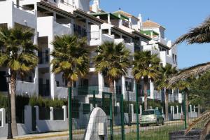 Un edificio con palmeras delante. en Playa Atlanterra, 1ª linea playa vistas al mar, en Zahara de los Atunes