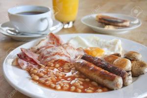 a plate of breakfast food with eggs sausage and beans at The Barn, Bellingham in Hexham