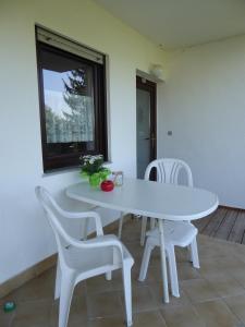 Una mesa y sillas blancas en una habitación con ventana. en Ferienwohnung Dora 2, en Michelstadt
