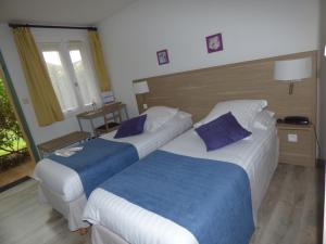 Habitación de hotel con 2 camas y almohadas azules en Hôtel Les Comtes de Pardiac, en Marciac