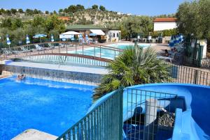 a large swimming pool with a blue fence around it at Villaggio Mare Blu in Vieste