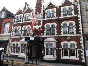 een groot bakstenen gebouw met een vlag ervoor bij The Kings Arms in Swindon