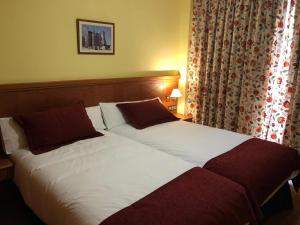 a bed with a white comforter and pillows at Hotel Camino Real in Arcahueja