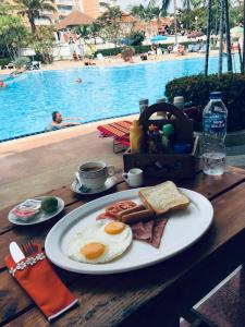 a plate of breakfast food on a table next to a pool at View Talay 1B Residence in Pattaya South