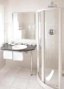 een witte badkamer met een wastafel en een douche bij Le Temple in NeuhÃ¼tten
