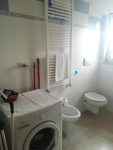 Un baño con lavadora y un inodoro. en Appartamento A Campobasso, en Campobasso