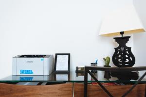a glass table with a printer and a lamp at Mi Rincon Central Apartment in Seville