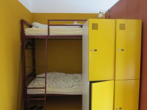 a bunk room with two bunk beds and a refrigerator at Basel Backpack in Basel