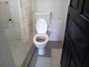 a bathroom with a white toilet in a stall at Ashari Hotel in Shanzu