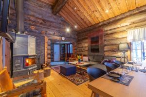 a living room with a fireplace in a log cabin at Kuukkeli Hirvas Suite in Saariselka