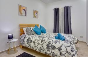 a bedroom with a bed with blue pillows on it at Luxury 3BR Apartment with Marina Views in Il-Gżira