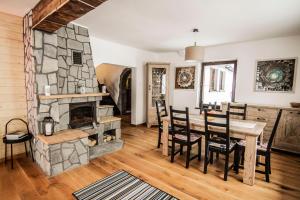 a living room with a stone fireplace and a table and chairs at Osada Koniaków in Koniaków