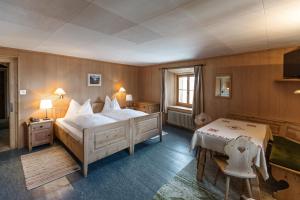 a bedroom with a large bed and a television in it at Hotel Klarer in Zuoz