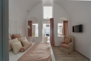 a living room with a couch and a chair at Senses Suites in Imerovigli +88 photos