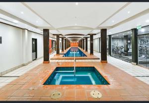a pool in the middle of a building with a swimming pool at Apartment Harborside Comfort in Sydney