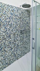 bagno con doccia e parete a mosaico di the blu and green apartment a Roma