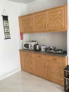 a kitchen with wooden cabinets and a counter top at View Talay 1 Jomtien in Pattaya South