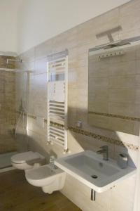 Vento Barocco - Equitazione e Turismo في ماتيرا: حمام مع حوض ومرحاض ومرآة
