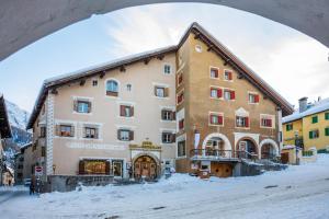 widok na budynek w śniegu w obiekcie Hotel Klarer w mieście Zuoz