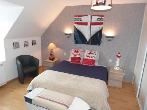 een slaapkamer met een bed met een boot aan de muur bij Le Trymen in Saint-Guénolé