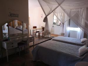 a bedroom with two beds and a mirror and a desk at Terra Rouge Guestfarm & Sonstraal Farmhouse in Koës