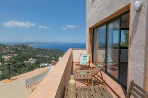 a chair on a balcony with a view of the ocean at 2 bedroom apartment in Begur center. Sea views, terrace and pool (Ref:H09) in Begur