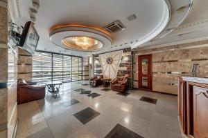 a lobby with chairs and a table in a building at Soborniy Hotel in Zaporozhye