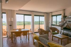 a living room with a couch and a table and chairs at 2 bedroom apartment in Begur center. Sea views, terrace and pool (Ref:H09) in Begur