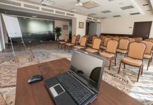 a laptop sitting on a table in a room with chairs at IBIS Styles Kaunas Centre in Kaunas