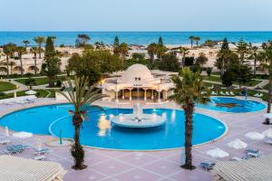 - une vue aérienne sur un complexe avec une piscine et l'océan dans l'établissement Le Royal Hammamet, à Hammamet