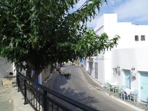 a street with a tree and white buildings at Alexandros House in Apollonia