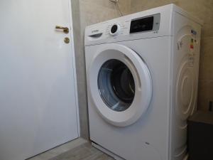 a white washing machine sitting next to a door at Alexandros House in Apollonia