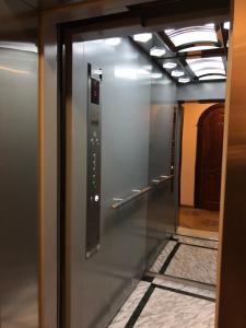 un ascenseur dans un couloir avec une porte en verre dans l'établissement Zhuliany City Hotel, à Kiev