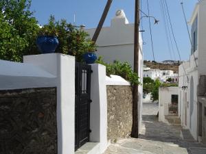an alley with blue vases on a white wall at Alexandros House in Apollonia