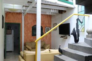 uma sala de estar com um sofá e uma televisão em Hostel 33 Brazil em Guarulhos