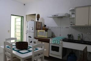 a kitchen with a white refrigerator and a table and chairs at Hostel 33 Brazil in Guarulhos