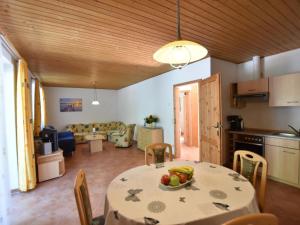 a kitchen and living room with a table with a bowl of fruit at Farm holiday home in Damshagen with garden seating and sauna in Klütz