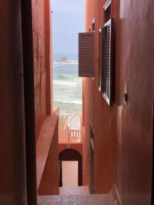 an alley with a view of the ocean from a building at HOTEL BEACH CLUB LEGZIRA in Sidi Ifni