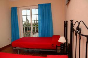 a bedroom with a red bed and a window at Casa Maestro Agustín Nº 1 in Valle Gran Rey