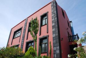 ein rotes Gebäude mit einem Kaktus davor in der Unterkunft Yuremar La Puntilla Apt. Nº 1 in Valle Gran Rey