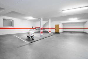 an empty parking garage with a scooter in the middle at Arbea Apartments in Ortisei