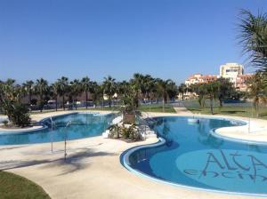 una gran piscina en un complejo con palmeras en Alta Entinas, en Almerimar