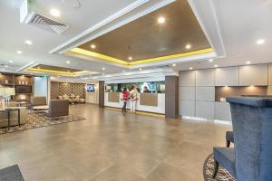 a lobby with two people standing in a building at City apartment at College St in Sydney