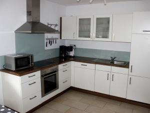 a kitchen with white cabinets and a microwave at Ferienhof Huber in Oberkirch