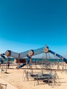 a playground on a beach with a slide at Motel Hofim in Bat Yam
