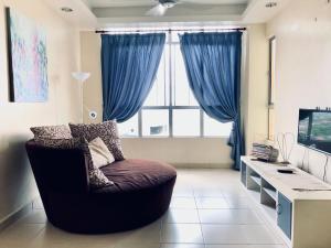 a living room with a chair in front of a window at Sultan Bridge Place in Kota Bharu