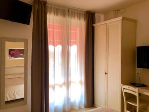 a bedroom with a window with a bed and a dresser at Villa Emma Malcesine in Malcesine