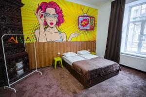 a bedroom with a bed with a painting on the wall at Pop Art Hostel in Lviv