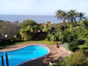 a swimming pool with the ocean in the background at Wailana lodge in Ramsgate